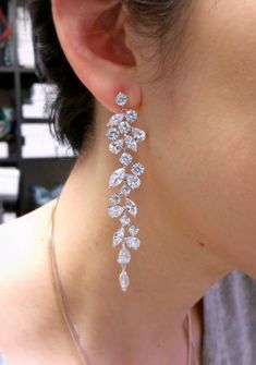 a close up of a person wearing some kind of earring with diamonds on it