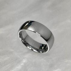 a white gold wedding ring on top of a white cloth covered surface with the word,'i do not know what this is