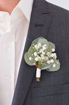 a man wearing a suit and tie holding a boutonniere with flowers on it