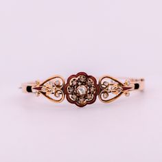 Embrace the enchanting allure of the Victorian era with this exquisite antique bracelet. Crafted in 14K rose gold, this stunning piece features a delicate outline of a red enamel flower, adorned with shimmering rose-cut diamonds, bezel, and prong set. The heart-shaped sides add a touch of romantic elegance to the design, transporting you to a time of opulence and refined beauty. The 14K rose gold setting serves as the perfect backdrop for the diamonds and enamel, enhancing their beauty and addin Elegant Engraved Rose Gold Bracelet, Luxury Yellow Gold Bracelets With Rose Cut Diamonds, Luxury Gold Bangle With Rose Cut Diamonds, Luxury 14k Rose Gold Jewelry With Rose Cut Diamonds, Vintage White Gold Bracelet With Single Cut Diamonds, Vintage White Gold Bracelets With Single Cut Diamonds, Luxury Gold Bracelets With Rose Cut Diamonds, Heirloom Rose Cut Diamond Jewelry In Rose Gold, Heirloom Rose Gold Jewelry With Rose Cut Diamonds