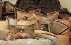 a bed with many pillows on it and a chandelier hanging from the headboard