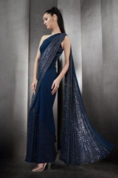 Navy saree gown with sequin embellishments.
Component: 1
Pattern: Embellished
Type Of Work: Sequins
Neckline: One Shoulder
Sleeve Type: Sleeveless
Fabric: Georgette
Color: Blue
Other Details: 
Strappy back
Closure: Back zipper
Occasion: Cocktail, Bride - Aza Fashions Blue Hand Embellished Pre-draped Saree For Festive Occasions, Blue Evening Dress With Mirror Work, Embellished Blue Anarkali Pre-draped Saree, Anarkali Pre-draped Saree With Sequins For Evening, Blue Floor-length Pre-draped Saree With Mirror Work, Blue Hand-embellished Pre-draped Saree, Blue Hand Embellished Pre-draped Saree For Wedding, Evening Gown With Dupatta In Traditional Drape, Traditional Evening Gown With Dupatta