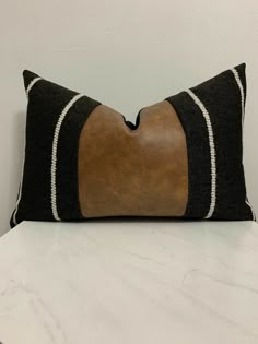 a black and brown pillow sitting on top of a white counter next to a wall