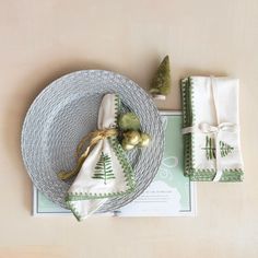 a place setting with napkins and christmas decorations