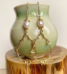 Enhance your boho chic style with this set of long gold teardrop-shaped flower branch dangly earrings. Featuring large gold-plated brass flower branch charms, these earrings are delicately crafted and exude a sweet charm. The handmade earring hooks, crafted with 10K gold-filled wire, add a touch of elegance. At the top, white freshwater pearls with gold-plated floral bead caps provide a classic and timeless accent. Measuring 2 1/2" X 7/8", including the gold-filled wire hooks, these earrings are a beautiful choice for Christmas gifts, birthdays, weddings, or any special occasion. Embrace the allure of boho chic with these intricate and stylish flower branch earrings. Bridal Pearl Earrings, Branch Earrings, Bridal Earrings Pearl, Handmade Earring, Boho Chic Style, Flower Branch, White Freshwater Pearl, Dangly Earrings, Bridal Pearls