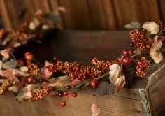 an old wooden box with red berries and leaves on it