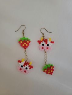 the earrings are made out of legos and have fruit charms hanging from it's earwires