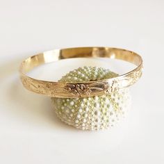 Traditional Hawaiian heirloom bangle is make with decorative floral pattern wire. Bangle is hand- formed, hammered and polished for a stunning texture and shine. It looks great worn alone or paired with other shell and charm bangles to create a chic, fun beachy look. Bangle is about 8mm wide 1.2 mm thick. Each bangle is custom made to order so can not be return or exchange for that reason. Please don't hesitate to contact me if you have any questions at all before ordering. PLEASE NOTE THERE IS Charm Bangles, Bangle Gold, Hawaiian Jewelry, Gold Bangle, Tahitian Pearls, Charm Bangle, Hand Crafted Gifts, A Bracelet, Bar Necklace