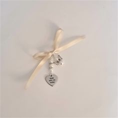 "This is a beautiful charming handmade silver bridal bouquet charm with  a personalised \"Walk with me today\" charm and a  hand crafted angel charm . In this example, the \"Walk with me today\" charm is suspended beneath a string of 3 White Pearl Beads with 2 Diamante Rondelle Spacer beads between the pearls;   the angel charm is handcrafted from 2 White pearls and tibetan silver angel wings.  The bouquet charm is supplied with a 30 cms length of ivory ribbon, ready for you to attach to your bouquet, and  comes in a pretty organza gift bag. It will make a superb addition to your very special day.  You can change the colour of the angel and the colour of the pearl strings  for the \"Walk with me today\" charm at check out.  This listing is for a single  \"Walk with me today\" charm, and 1 Elegant Silver Wedding Charms, Elegant Wedding Charms With Vintage Style, Elegant Wedding Charms With Vintage Design, Elegant Vintage Wedding Charms, Charming Pendant Charms For Gift, Charming Pendant Charms As A Gift, Valentine's Day Wedding Jewelry With Vintage Charm, Gift Pendant Charms, Elegant Charms For Anniversary And Mother's Day