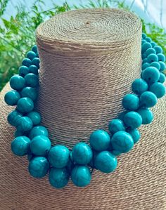 Make a statement with this Turquoise multi beaded Necklace. Made with various sized round beads threaded on black cotton.  Fastens with a metal hook. Measures: 45 cm. HANDMADE & FAIRTRADE. Other colours are available in this necklace. Please look at our shop to find other colour options.Items posted to addresses within the UK will be sent Royal Mail 1st Class UK Standard. Overseas by Royal Mail International Tracked and Signed. Turquoise Necklace With Large Beads, Turquoise Necklace With Large Round Beads, Turquoise Multi-strand Beaded Necklace With Large Beads, Turquoise Necklace With Wooden Beads, Turquoise Necklace With Wooden Round Beads, Turquoise Necklaces With Round Wooden Beads, Turquoise Wooden Beads For Jewelry Making, Turquoise Necklace With Round Wooden Beads, Turquoise Large Beads