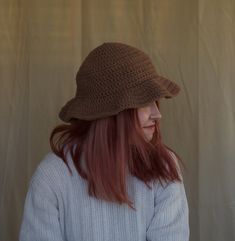 a woman with red hair wearing a brown hat