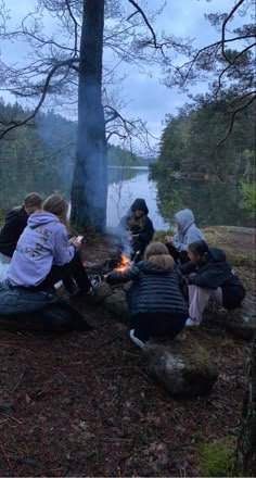 people sitting around a campfire in the woods