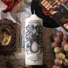 an octopus candle sitting on top of a table next to some grapes and other items