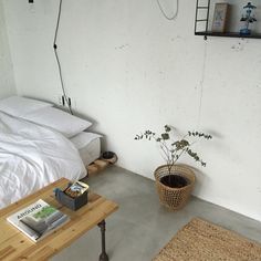 a bed sitting next to a wooden table on top of a hard wood floor