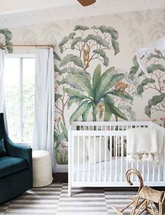 a baby's room with a wallpapered jungle theme and a white crib in the foreground