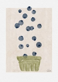 blueberries falling into a green bowl on top of a white paper sheet with watercolor stains