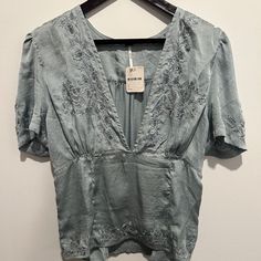 Nwt Free People Short-Sleeve Deep-V Shirt In Blue (Medium Blue) (Size L). Shirt Features A Deep-V At The Front With Darting At The Midriff. Extensive Embroidery With Lace Insets At The Neckline, Hemline, On The Sleeves, And On The Back. Center Back Is Elasticized To Provide Stretch And Freedom Of Movement. Shirt Is Completely Brand New, Never Used. Perfect Condition. No Flaws, Damage, Or Imperfections Whatsoever. Super Cute Shirt! Perfect For So Many Occasions. Floral Embroidered V-neck Top With Relaxed Fit, Relaxed Fit V-neck Embroidered Top With Floral Embroidery, Relaxed Fit V-neck Top With Floral Embroidery, Chic Fitted V-neck Embroidered Top, Chic V-neck Fitted Embroidered Top, Spring Embroidered V-neck Top With Relaxed Fit, V-neck Embroidered Top For Spring With Relaxed Fit, Blue V-neck Top With Floral Embroidery, Chic V-neck Top With Floral Embroidery