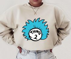 a woman wearing a sweatshirt with the word thing 2 printed on it