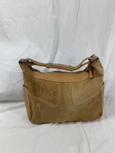 "Measurements are 14\" top wide, 9\"5 high, 5\" deep with one 13\" shoulder strap with a 5\" drop. This bag is adorned with one main compartment, back zipper pocket, lined in brown fabric and a top zipper closure. The leather is nice and strong with no tears and there is minor balding on calf hair. Bag has all working zippers, 4 exterior pockets, light stitching and bag is spacious. Made in Italy with serial# L8 07 and is 100% genuine Tod's. -----------------------------------------I SHIP WORLDW Designer Suede Shoulder Bag With Detachable Strap, Tan Leather-lined Shoulder Bag, Tan Leather Lined Shoulder Bag, Designer Suede Shoulder Bag For Daily Use, Vintage Beige Leather Hobo Bag, Brown Suede Top Handle Hobo Bag, Tan Leather Shoulder Bag With Leather Trim, Suede Shoulder Bag With Leather Lining, Designer Suede Top Handle Shoulder Bag