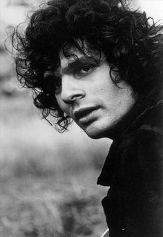 a black and white photo of a man with curly hair