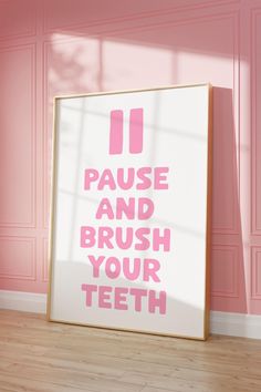 a pink poster with the words pause and brush your teeth on it in front of a pink wall