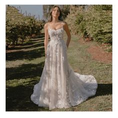 a woman in a wedding dress standing on the grass