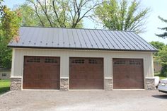 three garages with two cars parked in front of them