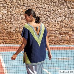 a woman standing on top of a tennis court holding a racquet in her hand