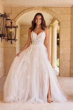 a woman in a white wedding dress posing for the camera