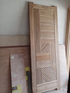 a wooden door sitting in the middle of a room next to plywood planks