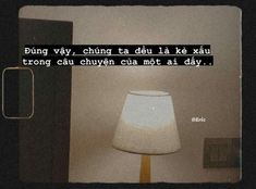 a lamp sitting next to a wall with a quote written on the side of it