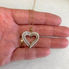 "Up for sale is this vintage estate 10 karat solid yellow gold baguettes and round diamond heart 18\" necklace, never used w/original boxes and tag.  The necklace chain is a delicate pendant chain measuring 18\" long.  The heart pendant features round bezel set diamonds and baguette channel set diamonds set into the heart design (diamonds have been tested genuine).  The attached tag reads 1CTTW AA6/7 10KYG BAG&RD HRT P. The pendant measures 7/8\" wide by 1\" high.  The reverse of the pendant is marked 10K.  The chain closes with a spring ring clasp.  The spring ring is marked 10K.  The necklace was sold to us in the original boxes and the original tag noting $1500 as the original retail price is still attached.  Note that some photos are enlarged to show details. Condition:  This pendant n 14k Gold Heart Pendant Diamond Necklace For Anniversary, Fine Jewelry Diamond Cut Anniversary Gift, Fine Jewelry Diamond Cut For Anniversary Gift, Yellow Gold Heart Cut Dazzling Jewelry, Diamond Cut Jewelry For Anniversary Gift, Dazzling Yellow Gold Heart Cut Jewelry, Dazzling Heart Cut Yellow Gold Jewelry, Yellow Gold Diamond Open Heart Jewelry, Yellow Gold Open Heart Diamond Jewelry