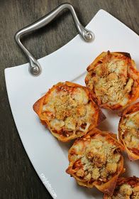 several mini pizzas on a white plate with a metal clip in front of them