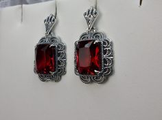 Simulated Red Ruby Solid Sterling Silver Earrings Short Festoon Design#E8z (shorter version) These Victorian reproduction estate earrings are solid sterling silver. These filigree earrings have stunning simulated red ruby gemstones. Each stunning gem is 10mm x 8mm x 5mm in dimension. The earrings are approximately 1/2" x 1" (13mm x 23mm). The unique earrings are marked 925 for solid sterling silver. These lovely earrings were refashioned from an antique Victorian cameo necklace. Quintessentially Red Jewelry Set, Jeweled Flowers, Armenian Jewelry, Pendant And Earring Set, Red Stone Ring, Marcasite Jewelry, Antique Filigree, Filigree Jewelry, Mid Century Jewelry