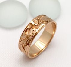 a gold wedding ring with flowers on it