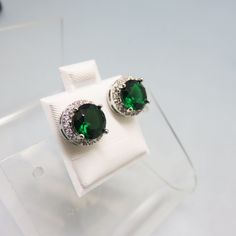 These classic emerald and clear cubic zirconia earrings are gorgeous.  They measure 3/8th inches in diameter. The metal is rhodium plated and they are in MINT condition.  Think ahead to the holidays. These would be smashing with a simple suit or dress.   We will send these to you in a lovely gift box for stellar gift presentation. If you like old sterling silver jewelry, bolo ties, vintage costume jewelry and accessories, kindly check out my store for more delights!   www.etsy.com/shop/PANDPF Green Diamond Earrings For Formal Occasions, Classic Round Diamond Earrings For May Birthstone, Emerald Round Cut Earrings For Anniversary, Formal Earrings With May Birthstone In Round Cut, Round Emerald Earrings For Anniversary, Green Diamond Earrings With Brilliant Cut, Green Diamond Earrings With Halo Design For Anniversary, Classic Brilliant Cut Emerald Earrings, Emerald Round Earrings For Anniversary