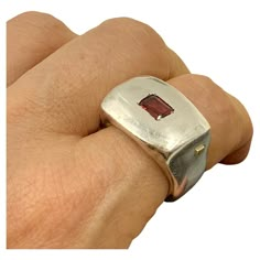 Bold, modern, sculptural, chunky garnet and sterling silver signet statement ring by Lebanese designer Rosa Maria. Marks: Rosa Maria, 925 for Sterling Silver Size: 8.5 Weight: 29.8 grams Condition: Very Good, light surface wear, nice patina Ring Face: 22mm by 15mm Garnet: 6mm by 4mm, emerald cut, lively burgundy Provenance: from the collection of a noted NYC psychiatrist and collector of unusual, often one-of-a-kind jewels. This sophisticated, modern Rosa Maria signet ring centers an emerald cut Grain Setting Jewelry, Chunky Statement Ring, Cast Rings, European Jewelry, Modernist Ring, Unusual Rings, Modernist Jewelry, Gold Ring Designs, Silver Signet Ring