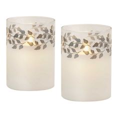 two white candles with silver leaves on them