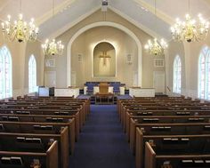 an empty church with pews and chandeliers