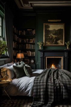 a bedroom with dark green walls and a fireplace in the corner is lit by two lamps on either side of the bed