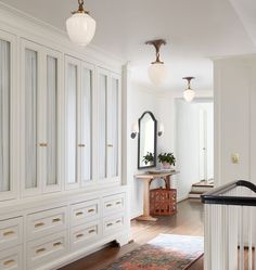 a room with white cabinets and a rug on the floor in front of an entry way