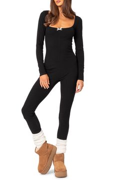 A stretchy ribbed design adds to the endless comfort of this cozy jumpsuit designed with long sleeves and a wide scoop neckline detailed with a dainty bow. Pull-on style Scoop neck Long sleeves 45% polyester, 45% rayon, 10% spandex Machine wash, dry flat Imported Winter Ribbed Stretch Bodysuit, Casual High Stretch Bodysuit For Winter, Winter Stretch Ribbed Bodysuit, High Stretch Casual Bodysuit For Winter, Casual High-stretch Winter Bodysuit, High Stretch Casual Winter Bodysuit, High Stretch Ribbed Jumpsuits For Loungewear, Black Stretch Ribbed Jumpsuits And Rompers, Casual Long Sleeve Ribbed Bodysuit