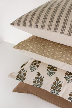 three pillows stacked on top of each other with different patterns and colors in the middle