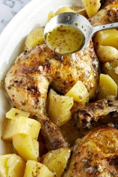 chicken and potatoes in a white bowl with a spoon on the side, ready to be eaten