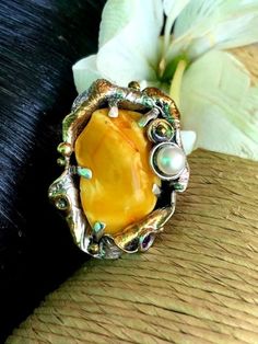 "Very Unique Baltic Amber Gemstone Ring in sterling silver with 24k Gold accents Hand-made Sterling Silver, 24k Gold, Size 9 Stones used: Baltic Amber, Pearl, Amethyst Face of the ring: Height - 40mm, Width-30mm Height - 1 3/8\", Width-1 1/4\" Band height - 10mm Unique Handcrafted One-of a-kind Design Ring Each Piece of Jewelry in my Collection is Absolutely One of a Kind! When you start wearing a piece of my jewelry you will fall in love with it more and more each day and feel that good Energy Artisan Gemstone Rings For Anniversary, Artisan Open Ring Gemstone Jewelry, Nature-inspired Natural Stones Jewelry For Anniversary, Unique Multi-stone Opal Ring In Gold, Unique Gold Opal Ring With Multi-stone, Artisan Gold Rings With Natural Stones, Collectible Gold Opal Ring With Gemstone, Gold Sterling Silver Rings With Natural Stones, Unique Amber Wedding Rings