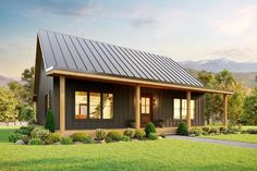 a small house with a metal roof in the middle of a grassy field and mountains behind it