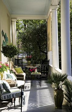 a porch with chairs and plants on it