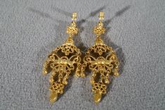 I am offering this fabulous vintage yellow gold tone pierced earrings. This piece is truly gorgeous, and it has the following features: * beautiful vintage earrings * yellow gold tone * chandelier style * faux amethyst * stud style * 2.5 inches in length This is a fantastic and classic piece. There is tons of sparkle and shine with this piece. It will beautifully complement your upcoming fashion season. Buyer pays all shipping and handling. Antique Filigree Chandelier Earrings For Formal Occasions, Ornate Evening Earrings With Intricate Design, Vintage Gold Bridal Earrings, Pierced, Vintage Gold Bridal Earrings, Ornate Bridal Earrings For Formal Occasions, Ornate Bridal Earrings For Festive Occasions, Antique Gold Party Earrings, Gold Antique Party Earrings, Antique Gold Earrings For Party