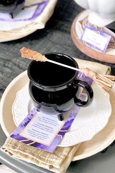 a black coffee cup sitting on top of a white plate