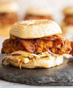 a fried chicken sandwich on a bun with coleslaw and ketchup